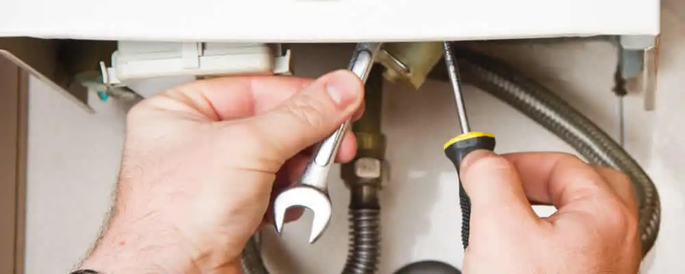 Boiler repair technician tightening pipe fittings and connections in Orlando, FL