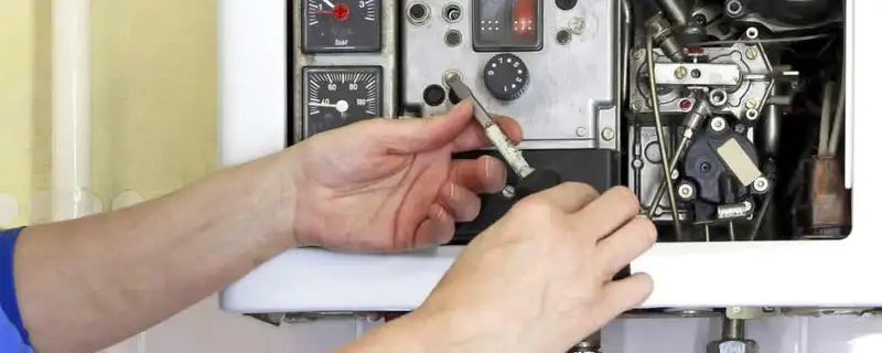 Heating repair technician adjusting boiler controls and components in Orlando, FL