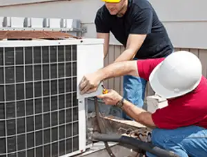 HVAC technicians repairing an outdoor AC unit on a rooftop in Orlando, FL