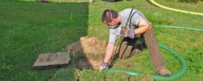 Septic pumping technician servicing a residential septic tank in Orlando, FL