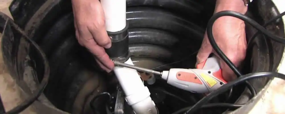 Sump pump installation technician connecting PVC discharge piping in Orlando, FL